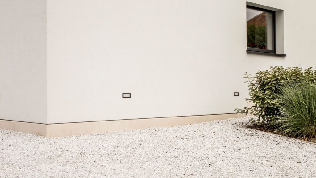wit grind aangelegd bij een crepi witte woning met zwarte accenten