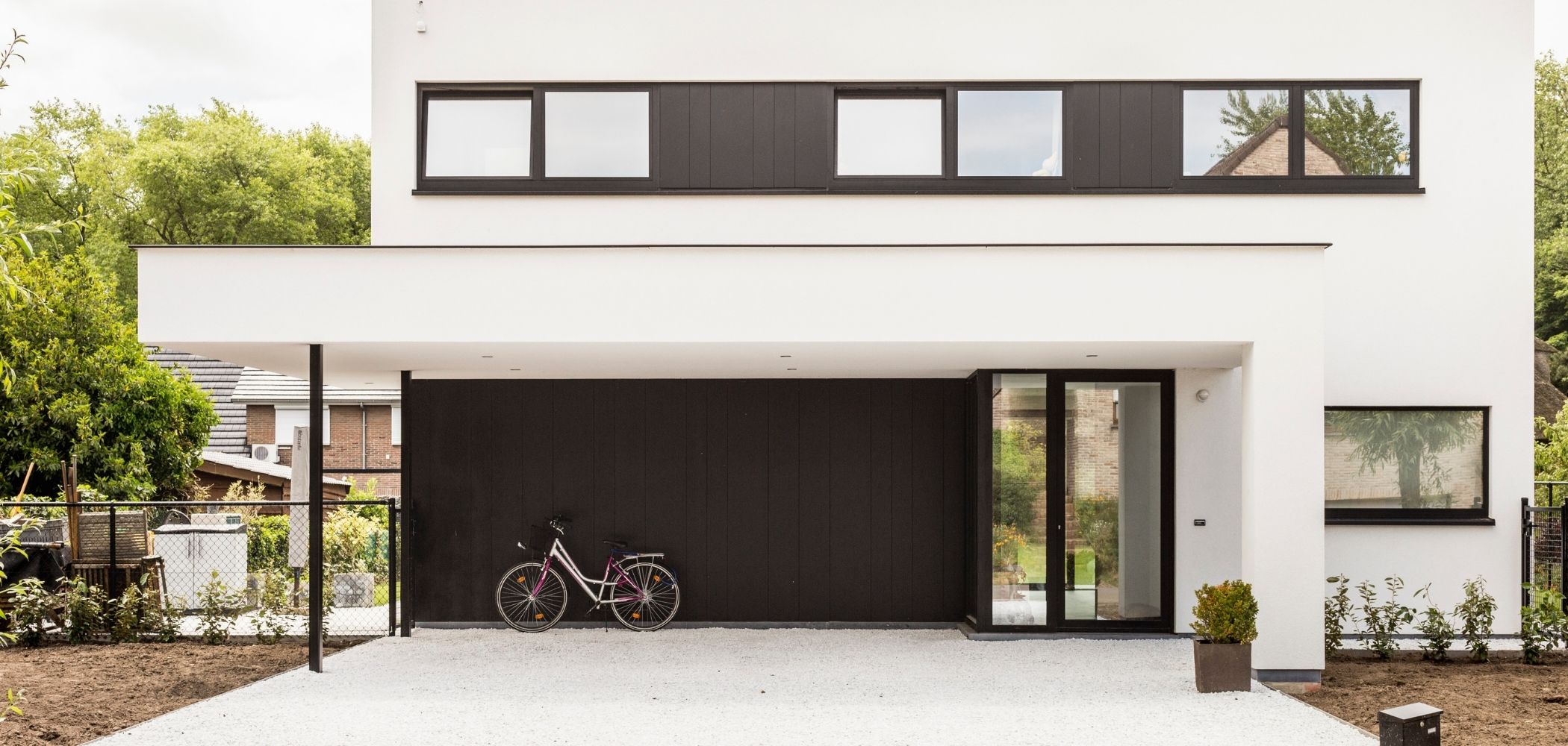 wit grind aangelegd bij een crepi witte woning met zwarte accenten
