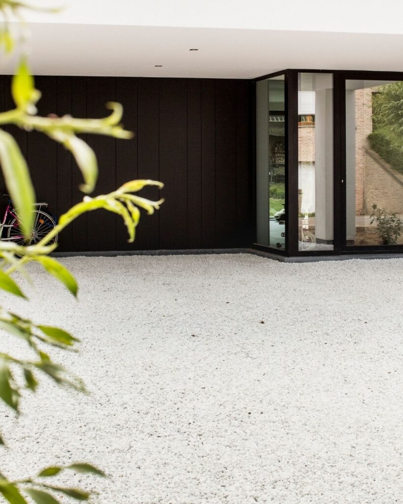 wit grind aangelegd bij een crepi witte woning met zwarte accenten