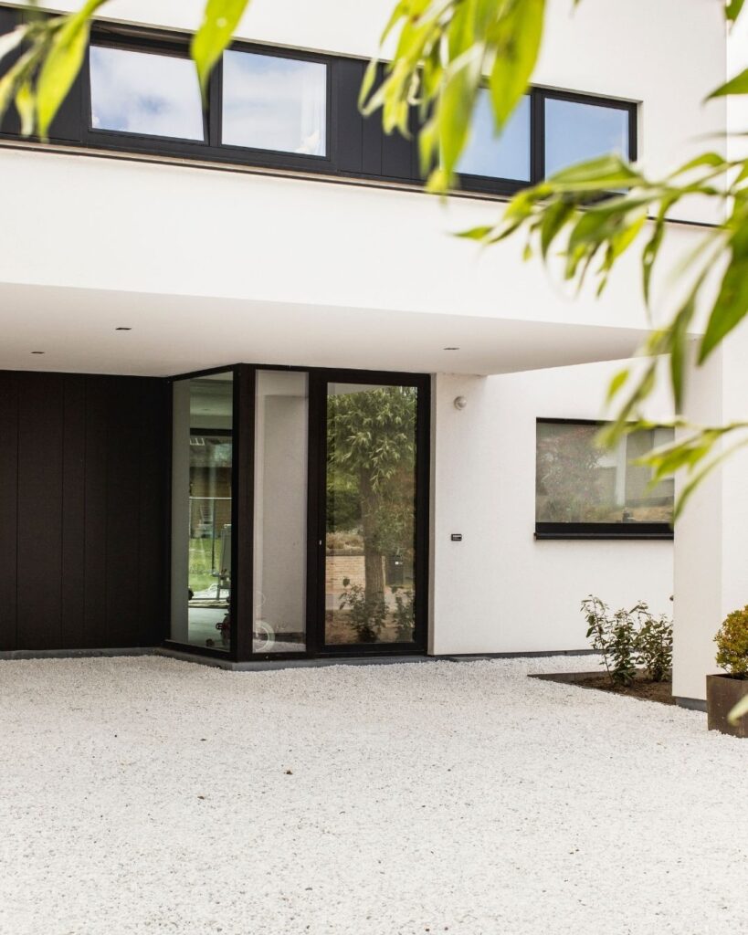 wit grind aangelegd bij een crepi witte woning met zwarte accenten
