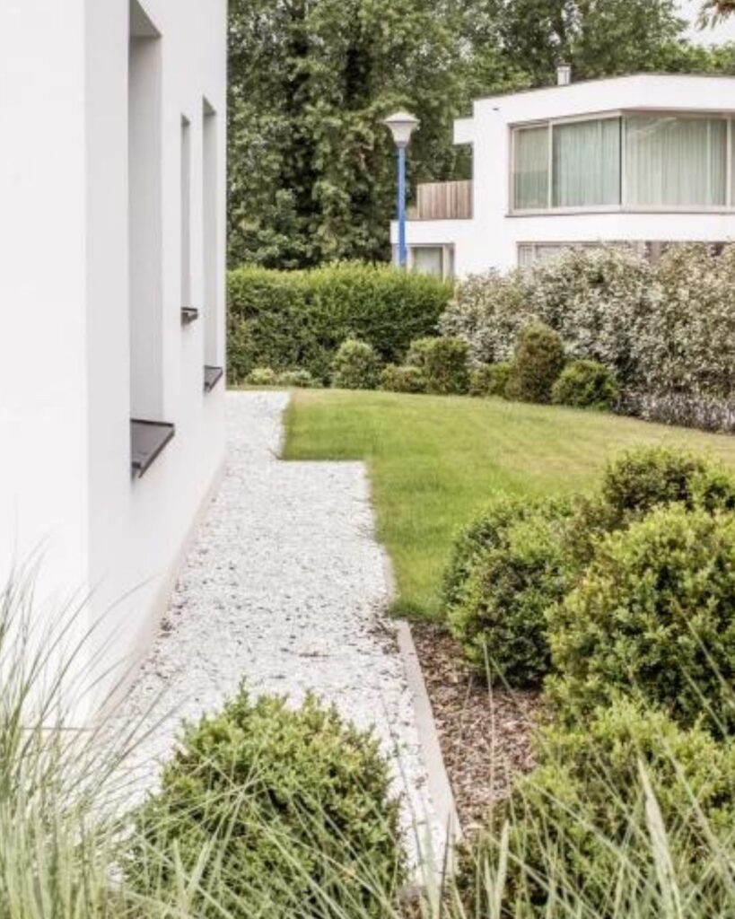 wit grind aangelegd bij een crepi witte woning met zwarte accenten
