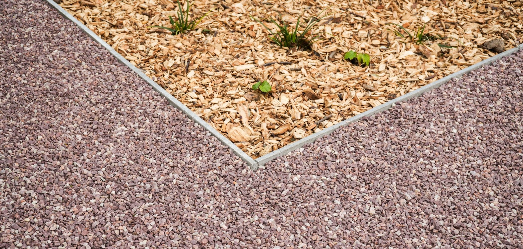 rood grind heritage oprit met betonnen afgeschuinde borduren en houtsnippers