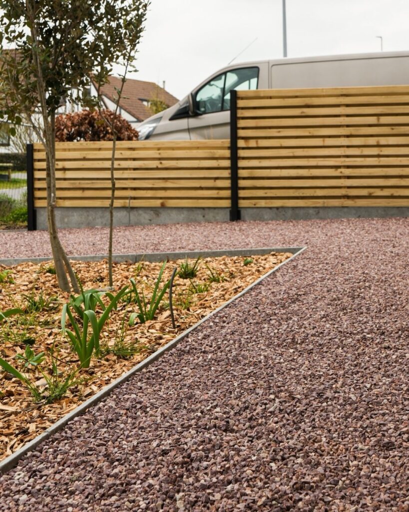 rood grind heritage oprit met betonnen afgeschuinde borduren en houtsnippers