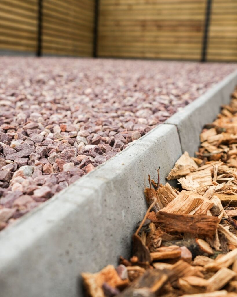 rood grind heritage oprit met betonnen afgeschuinde borduren en houtsnippers