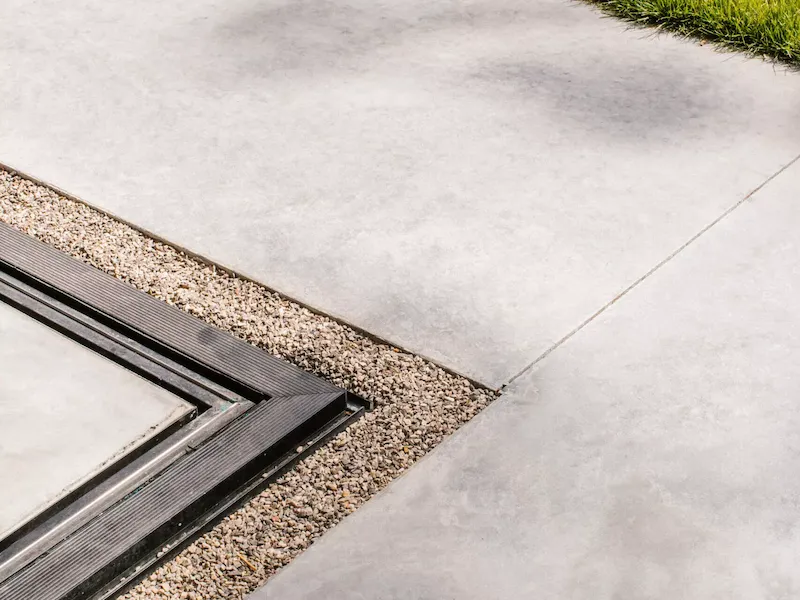Glad betonnen terras naast gazon
